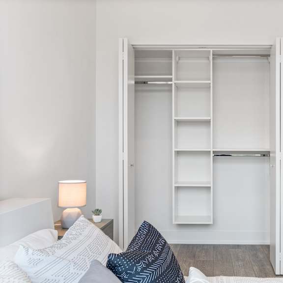 a bedroom with a spacious closets and a bed with blue and white pillows