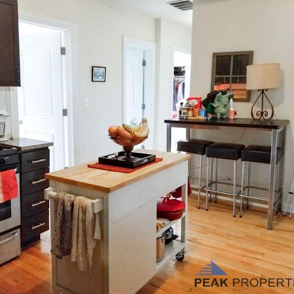 a kitchen with a island and a stove and a bar with stools
