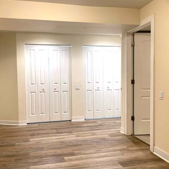 a living room with wood floors and white doors
