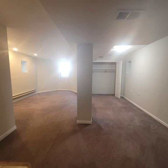 an empty living room with a carpeted floor and white walls