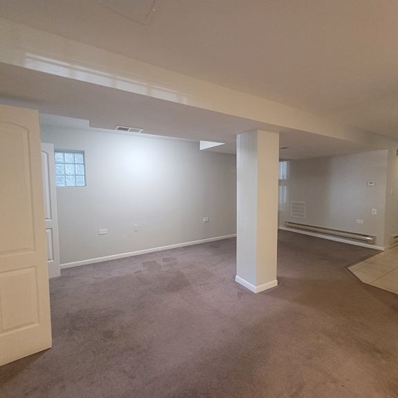 an empty living room with white walls and a concrete floor