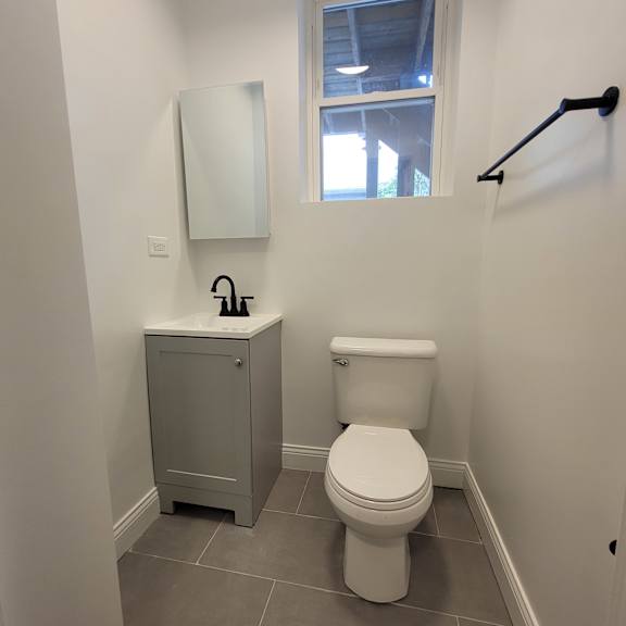 a white toilet sits next to a sink in a small bathroom.