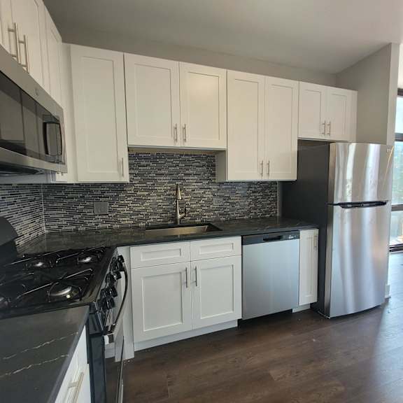 a kitchen with white cabinets and stainless steel appliances