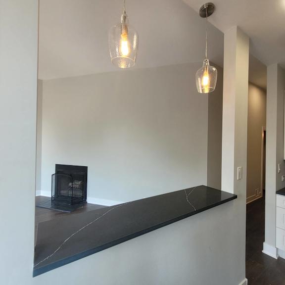 a living room with a fireplace and a long counter
