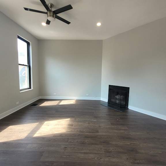 a living room with a fireplace and a ceiling fan