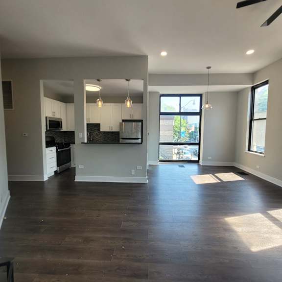 a kitchen and living room with wood floors and a window