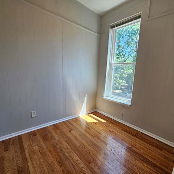 a room with wooden floors and a window.
