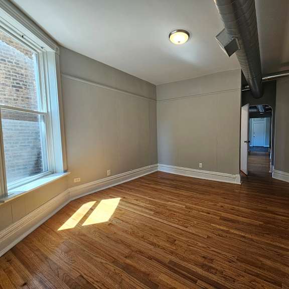 a room with wooden floors and white walls.