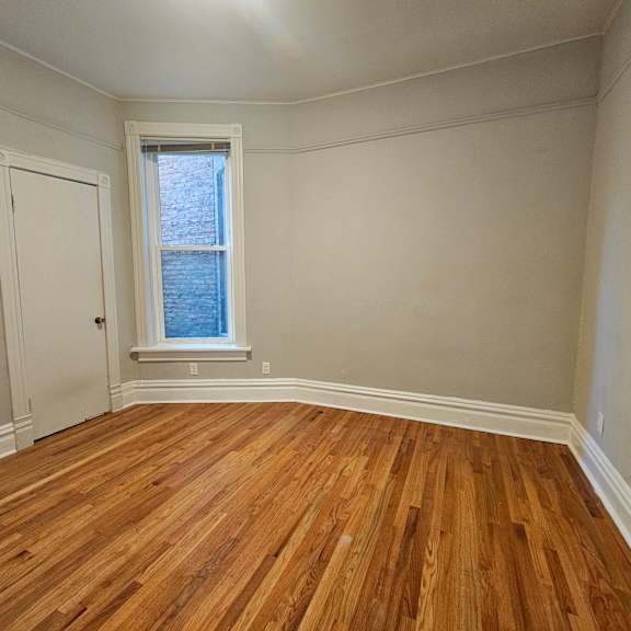 a room with wooden floors and a window.