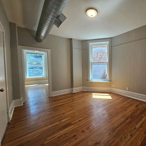 a room with wooden floors and a window.