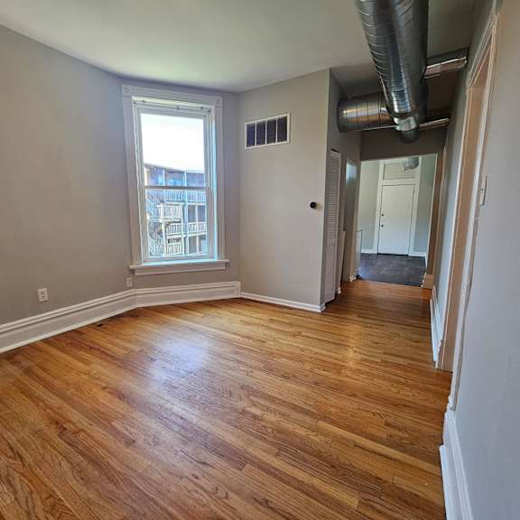 a room with wooden floors and a window.