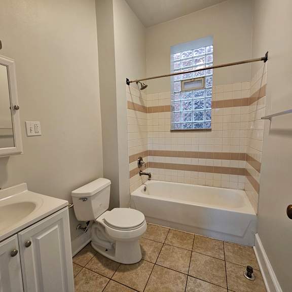 a white toilet sits next to a sink in a bathroom.