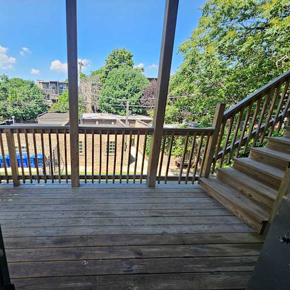 a wooden deck with a staircase leading to a house.