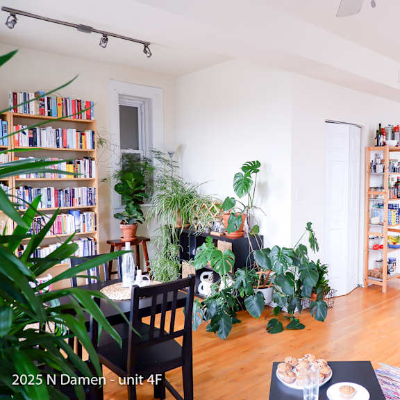 a living room with a dining table, chairs, and a bookshelf.