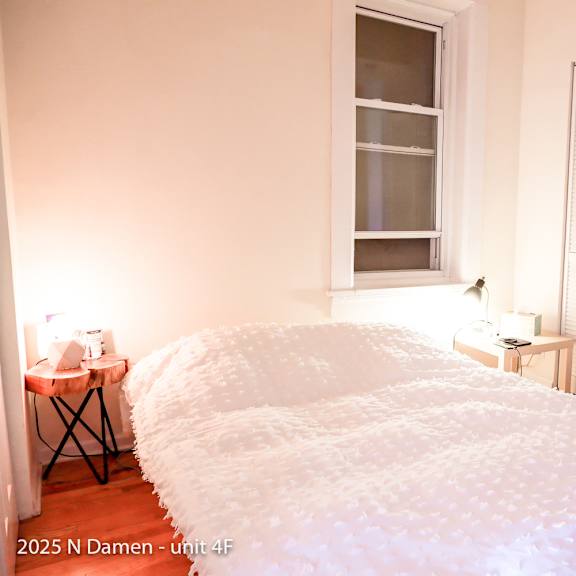 a bedroom with a large bed and a window with blinds.