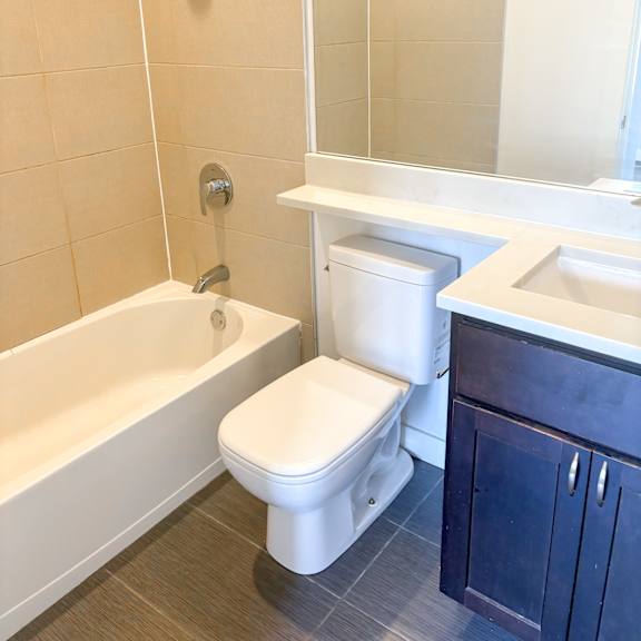 a white toilet sits next to a white bathtub in a bathroom.