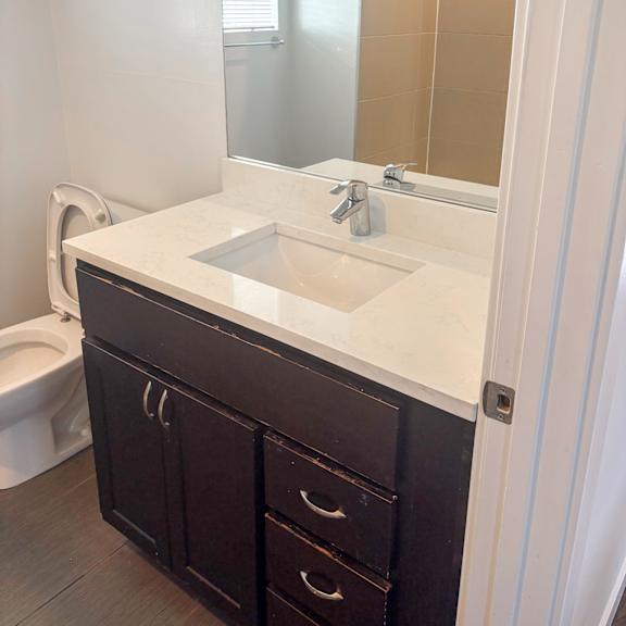 a white sink in a bathroom with a white counter top and a white toilet.