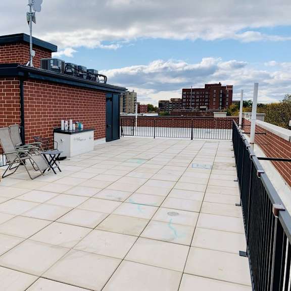 a rooftop patio with a table and chairs.