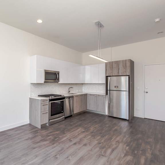 a kitchen with stainless steel appliances and white walls