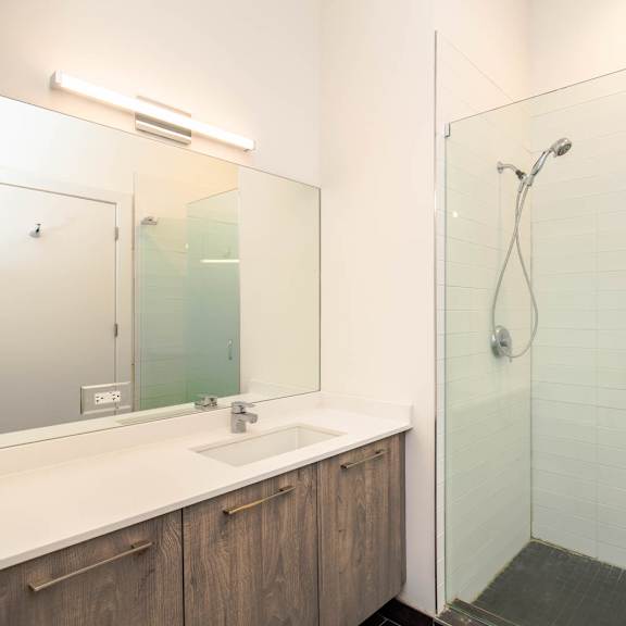 a bathroom with a shower and a sink and a mirror