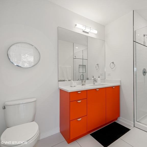 a bathroom with a red cabinet and a shower