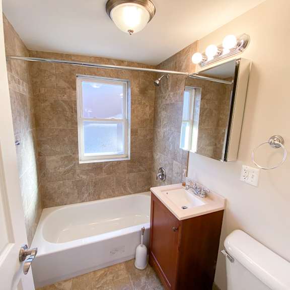 a bathroom with a tub and a sink and a mirror