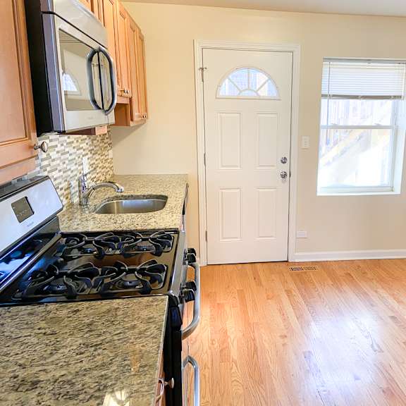 an empty kitchen with a stove and a white door