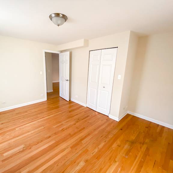 an empty living room with wood floors and white walls