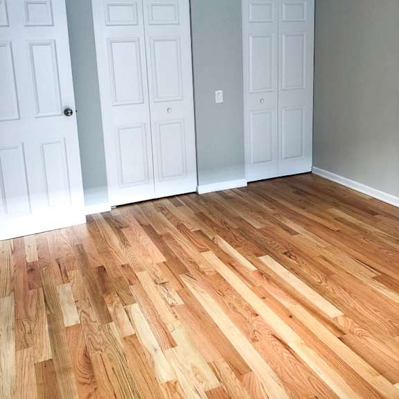 a room with three doors and a ceiling fan.