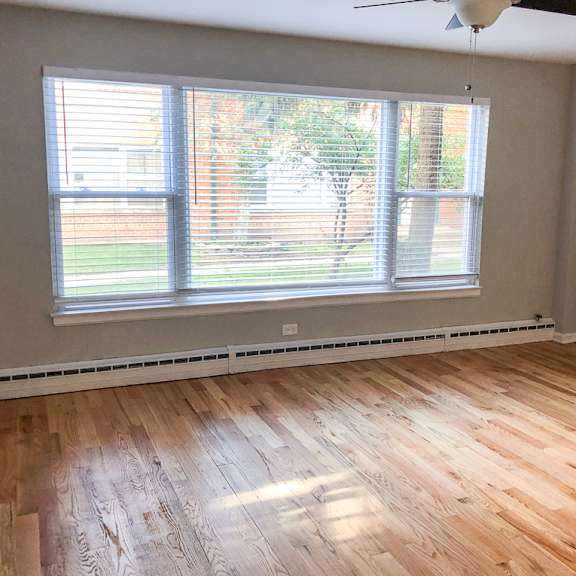 a room with a window and wooden flooring.