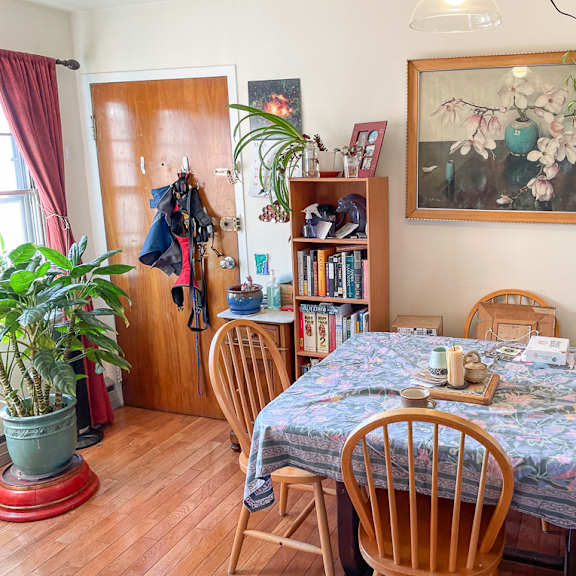 a dining room with a floral tablecloth and wooden chairs.