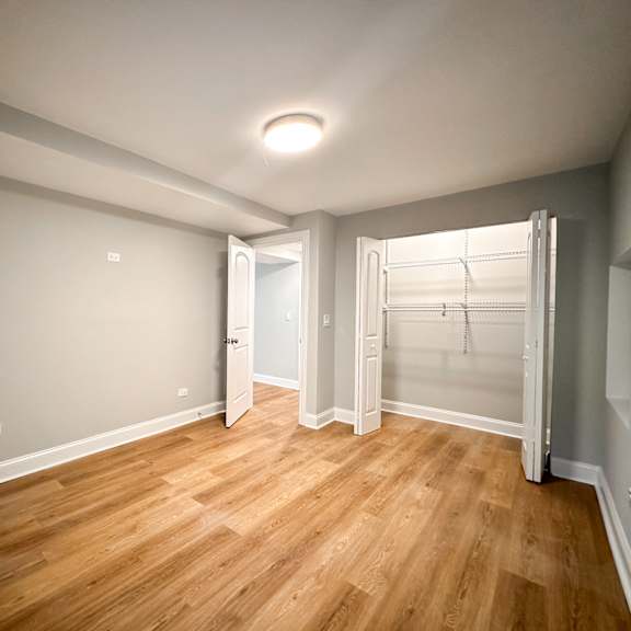a room with wooden flooring and a white door.