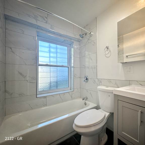 a white toilet sits next to a bathtub in a bathroom.