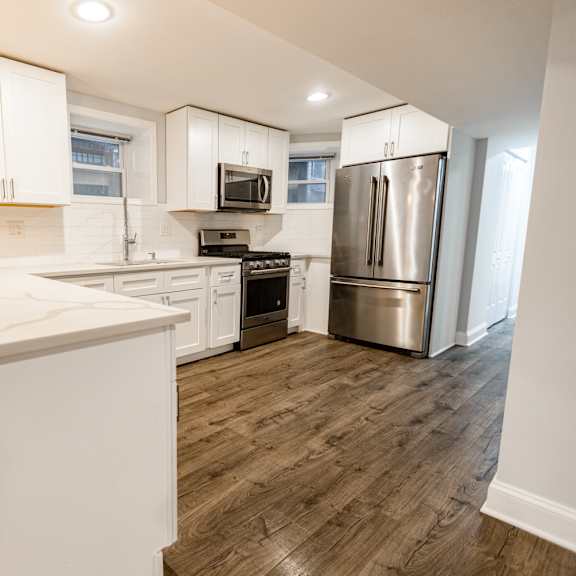 a kitchen with white cabinets and a wooden island.