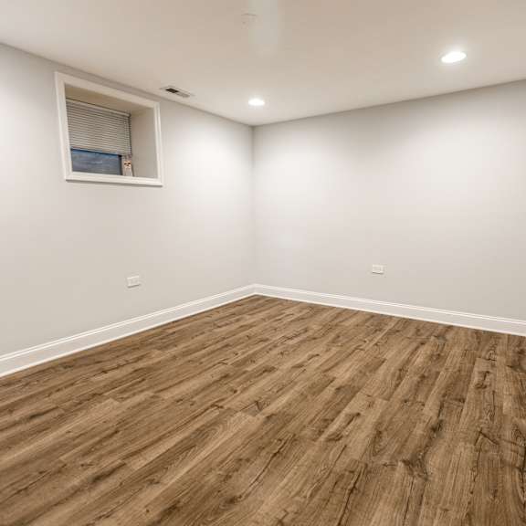 a room with wooden flooring and a small window.