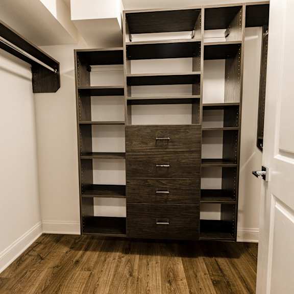 a tall wooden shelving unit with drawers is in a corner of a room.