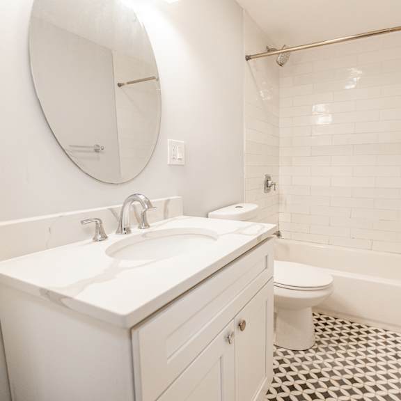 a white bathroom with a sink, toilet and bathtub.