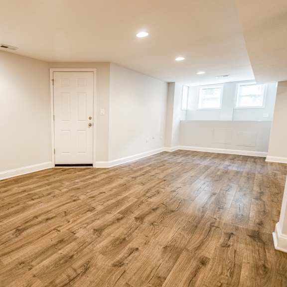 a room with wooden flooring and a white door.