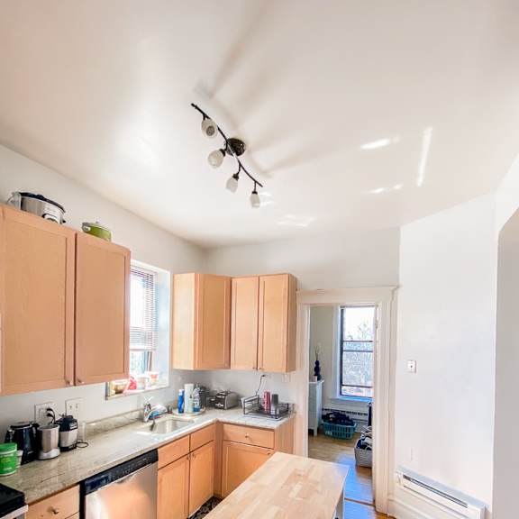 a kitchen with wooden floors and white walls.