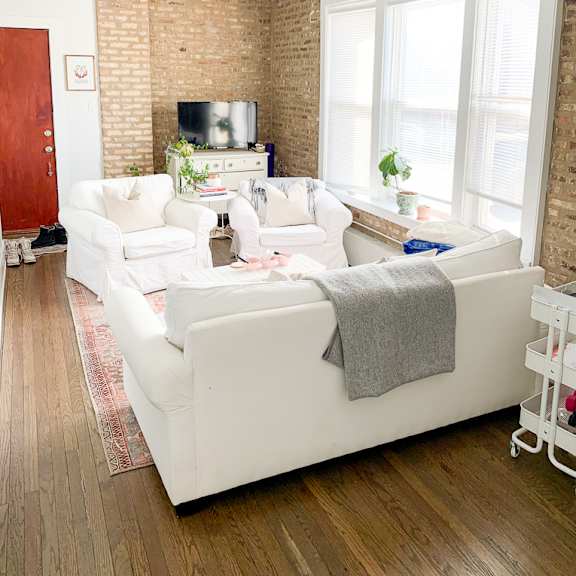 a living room with two white couches and a window