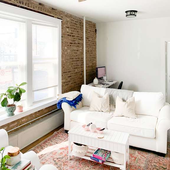 a living room with a white couch and a ceiling fan
