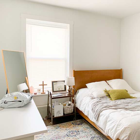 a bedroom with a bed and a desk and a window