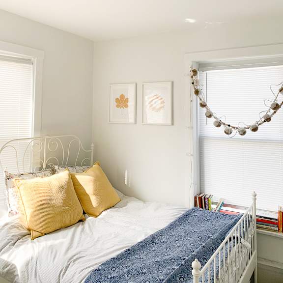 a bedroom with a bed with gold pillows and a blue blanket
