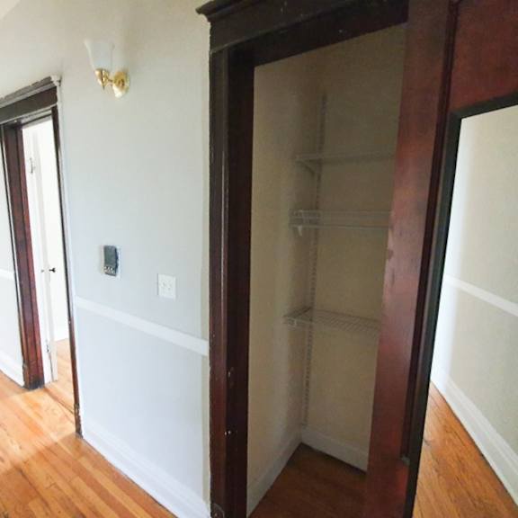 a white wall with a light switch and a door.