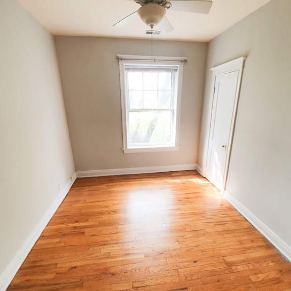 a room with a wooden floor and a ceiling fan.