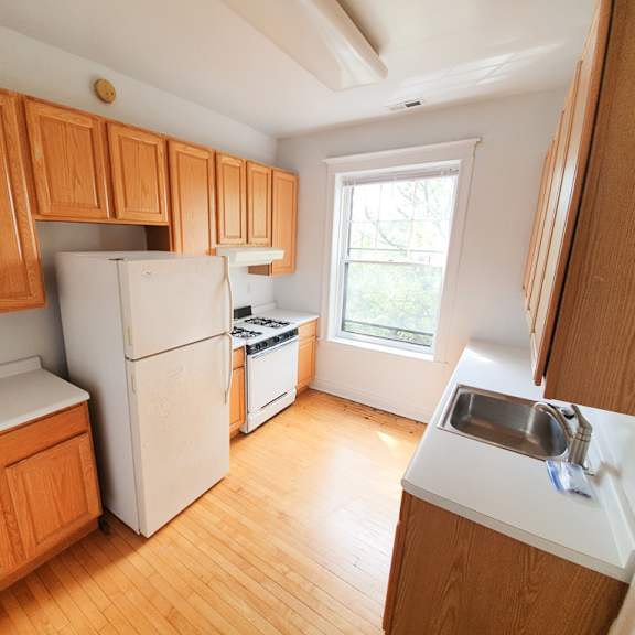 a kitchen with wooden cabinets and a white refrigerator.
