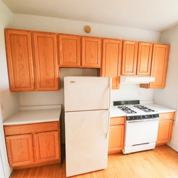 a kitchen with wooden cabinets and a white refrigerator.