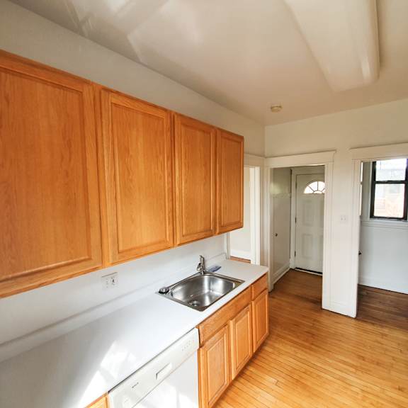 a kitchen with wooden cabinets and a white dishwasher.