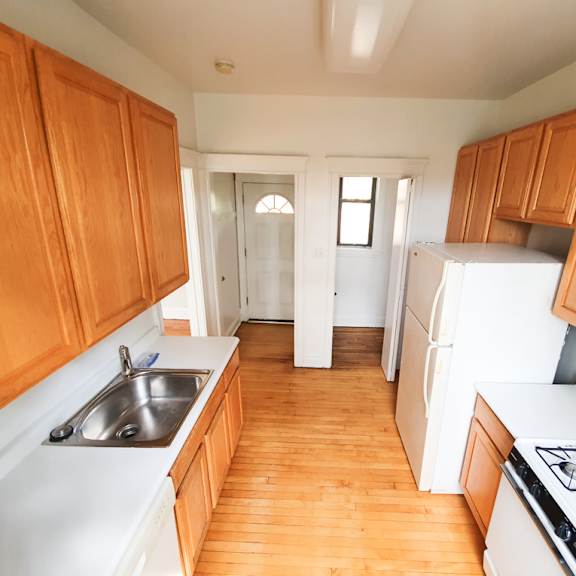 a kitchen with wooden cabinets and white appliances.