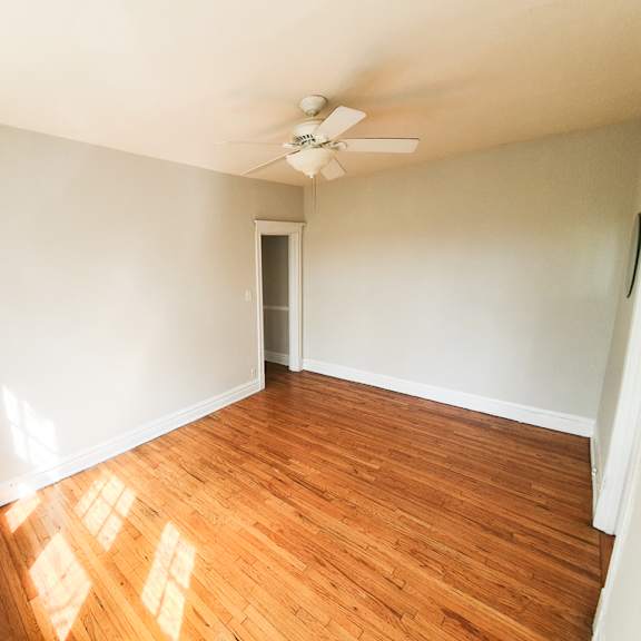 a room with wooden flooring and a ceiling fan.